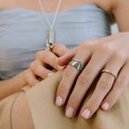 Velum stainless steel ring with drapery-inspired curved design and open back, worn on finger