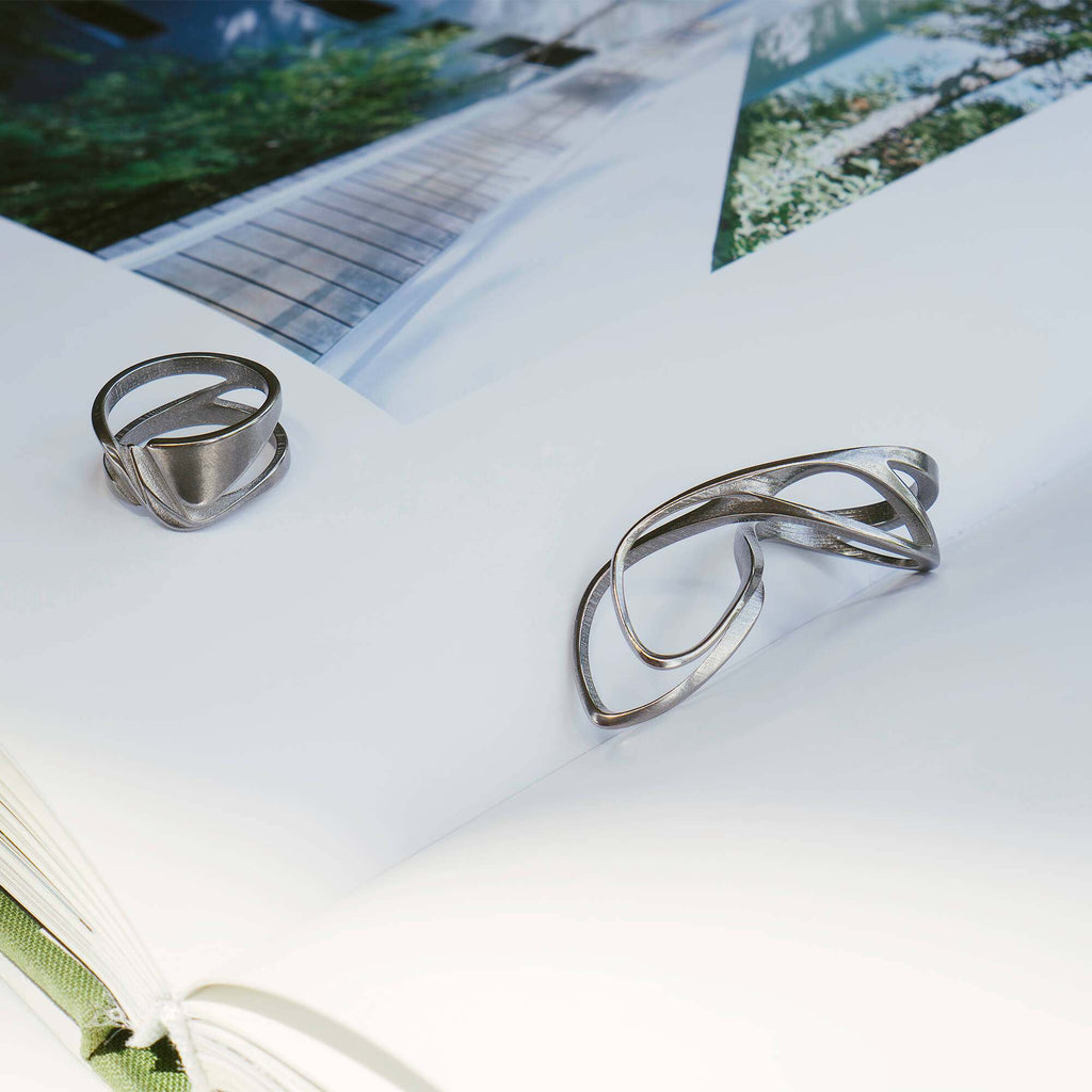 Velum Stainless Steel Ring with drapery-inspired curvature and open back design in stainless steel 316 and black PVD options.