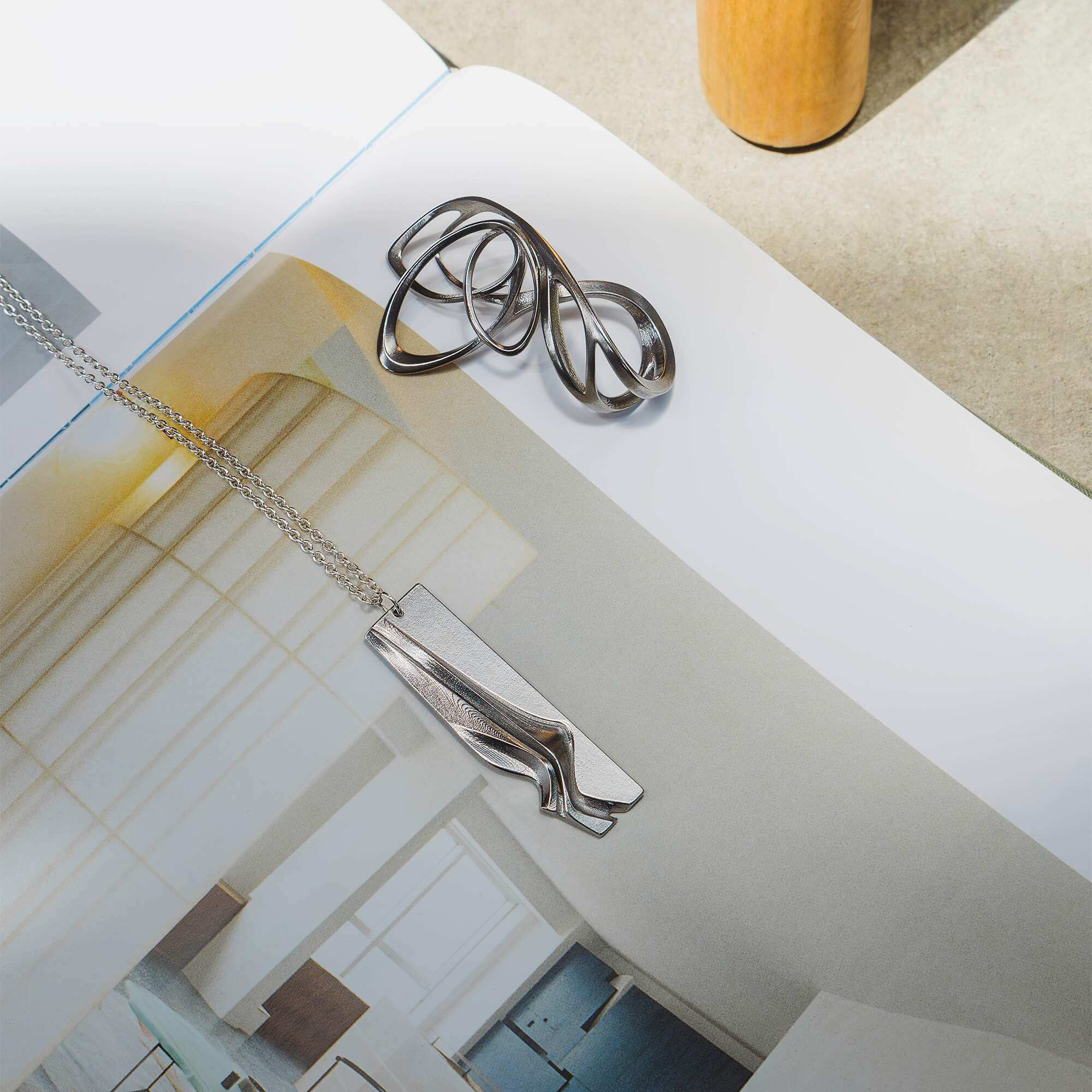 Nocturne Stainless Steel Pendant with twisting curves and precision edge detailing on a 22-inch chain