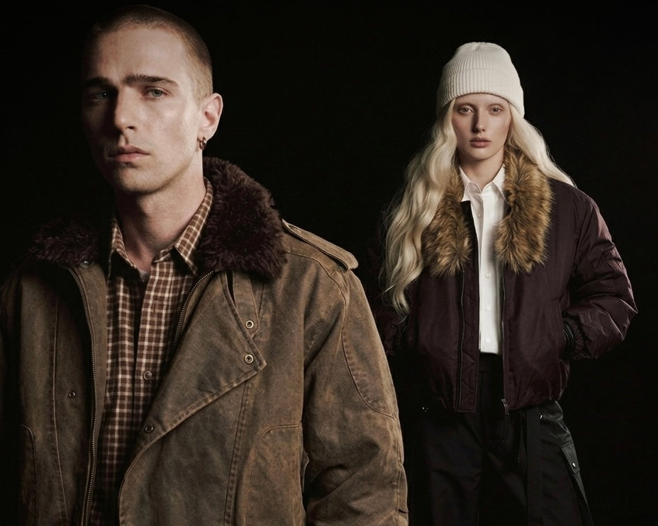 Two people wearing winter jackets and hats against a black background
